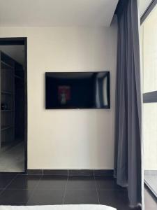 a living room with a television on a wall at AC Andares Tec Nespresso Estacionamiento Gratis 4p in Guadalajara