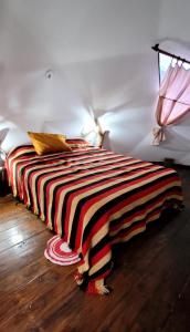 a bed with a striped blanket on the floor in a room at El Eden Nature Resort in Siambón +33 photos