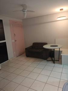 ein Wohnzimmer mit Tisch und Couch in der Unterkunft Apartamento central em Contagem in Contagem