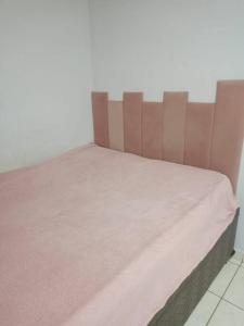 ein Bett mit einer rosa Decke darüber in der Unterkunft Apartamento central em Contagem in Contagem
