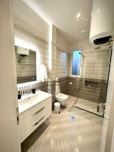 une salle de bain avec un lavabo, des toilettes et un miroir dans l'établissement Roman Apartments, à Vlorë