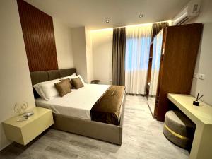 une chambre avec un lit et une grande fenêtre dans l'établissement Roman Apartments, à Vlorë