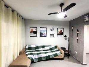a bedroom with a bed and a ceiling fan at Casa Ubatubana I, em Praia do Sapê - Ar condicionado, garagem, cozinha completa e Wi-Fi in Ubatuba