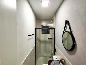 a bathroom with a glass shower and a mirror at Casa Ubatubana I, em Praia do Sapê - Ar condicionado, garagem, cozinha completa e Wi-Fi in Ubatuba +48 photos