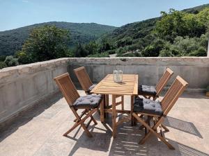 a wooden table and four chairs on a patio at Apartment Desanti 2 Valun in Valun