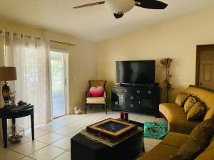 ein Wohnzimmer mit Couch und Flachbildfernseher in der Unterkunft - Spacious Master Room with Private Bathroom near UCF, Hospital & Shopping in Orlando