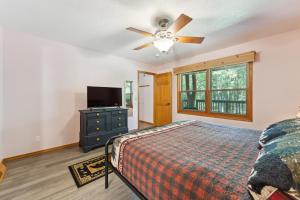a bedroom with a bed and a ceiling fan at Dog-friendly 6-acre 5BR 3BA home, game room, deck, Wisconsin Dells 10min in Lyndon Station