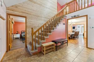 a wooden staircase in a living room with a table at Dog-friendly 6-acre 5BR 3BA home, game room, deck, Wisconsin Dells 10min in Lyndon Station