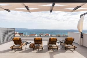 a group of chairs sitting on a balcony with a view at Villa AG in Podstrana