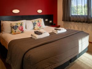 Un dormitorio con una cama grande con toallas. en Paroa Hotel, en Greymouth 48 fotos más
