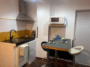 a small kitchen with a table and a microwave at La cerra -Tiny-house in Mijares