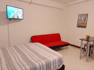 a bedroom with a red bed and a red chair at Departamentos Céntricos en Lima in Lima