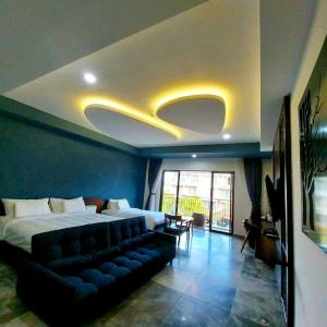 una camera d'albergo con un letto e un divano di MOJO Boutique HOTEL a Phu Quoc