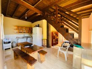 a kitchen with a wooden table and a staircase at Casa temporada na Gamboa - Garopaba-SC in Gamboa