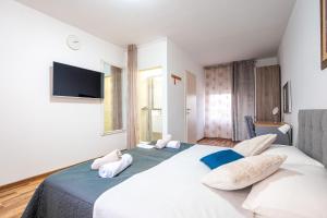 a bedroom with a large white bed with two pillows at Villa Leny with pool in Sukošan