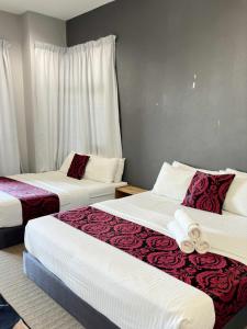 a bedroom with two beds with red and white sheets at Z&Z Studio Room in Kota Bharu