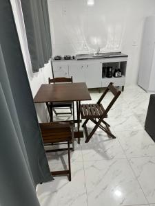 eine Küche mit einem Tisch, 2 Stühlen und einem Tisch in der Unterkunft Townhouse 03, Beto Carreiro 6Km, Praia Gravata in Navegantes