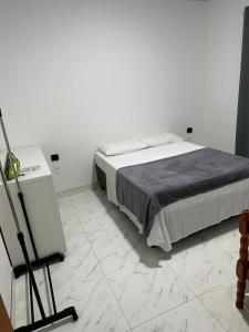 Bett in einem weißen Zimmer mit Kamera in der Unterkunft Townhouse 03, Beto Carreiro 6Km, Praia Gravata in Navegantes + 5 Fotos