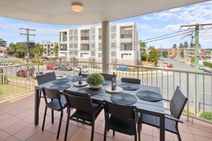 una sala da pranzo con tavolo e sedie su un balcone di Seagate Escape at Caloundra a Caloundra