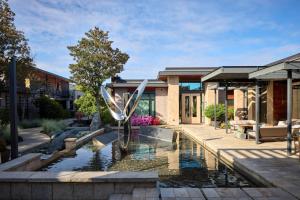 a fountain in front of a building with a house at Bardessono Hotel and Spa in Yountville