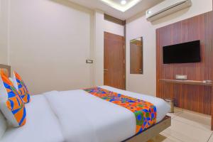 a bedroom with a white bed and a television at Hotel Maanvad Garh - V One pride by Noww Hotels in Udaipur