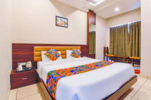 a bedroom with a large bed and a telephone at Hotel Maanvad Garh - V One pride by Noww Hotels in Udaipur