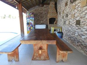 ein Holztisch in einem Raum mit zwei Bänken in der Unterkunft Casa de praia barra Serinhaém,Carneiros,ilha santo aleixo in Sirinhaém