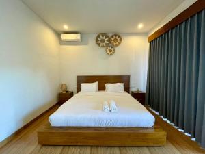 une chambre avec un lit avec deux chaussures dessus dans l'établissement Luana Villa Ubud, à Ubud 8 autres photos