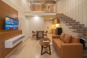 a living room with a couch and a staircase at Casa Residence Bali By Bali Cabin in Kerobokan