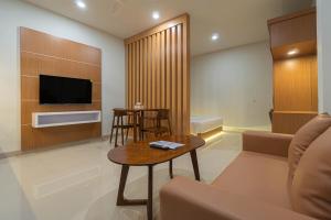 un soggiorno con un divano, una TV e un tavolo di Casa Residence Bali By Bali Cabin a Kerobokan