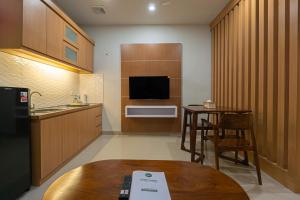 a kitchen with a table and a kitchen with a tv at Casa Residence Bali By Bali Cabin in Kerobokan