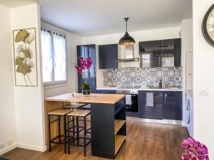 a kitchen with a island in the middle at T3 Moderne avec balcon terrasse et parking gratuit in Niort