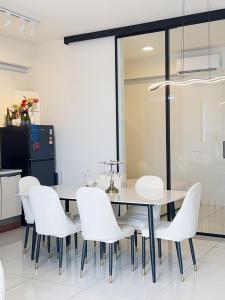 a dining room with a table and white chairs at Alpaca - Spacious Tranquil in Cheras