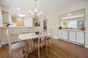 una cucina e una sala da pranzo con tavolo e sedie di 4D Crassostrea at True Blue condo by Peace Vacations a Pawleys Island