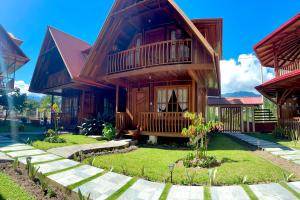 une maison en bois avec un balcon et une cour dans l'établissement DCampos Lodge, à Oxapampa