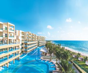 an aerial view of a resort with a swimming pool and the ocean at Generations Riviera Maya Oceanfront Family Resort, All & More Inclusive in Puerto Morelos