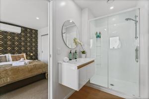 a white bathroom with a sink and a shower at Luxury & Modern Living Home & Apartment in Queenstown +15 photos