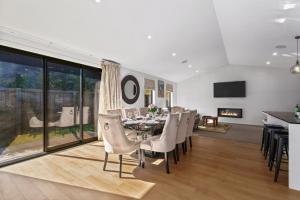 a dining room with a table and chairs and a fireplace at Luxury & Modern Living Home & Apartment in Queenstown