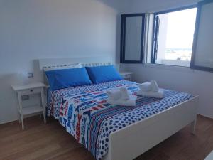 a bedroom with a bed with two towels on it at Sky and Sea Apartment Calasetta in Calasetta