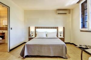 a bedroom with a large bed with white pillows at Residence Fort Savane in Fort-de-France