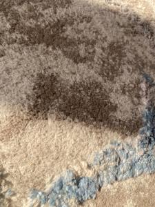 a black stain on the floor of auddle of water at ماريوت in Ali Al Salem Al Sabah