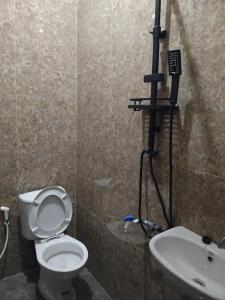 a bathroom with a toilet and a sink at Diara Bungalow in Iboih