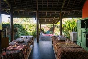 a room with four beds in a room with a tub at Floating Leaf Eco Resort in Gianyar