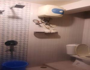 baño con aseo y dispensador de papel en la pared en Aamar Kutir by StayApart, en Siliguri