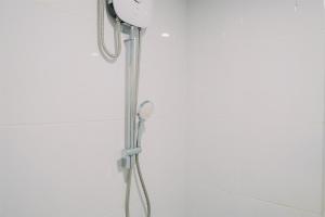 a shower with a shower head in a bathroom at Warm and Well Designed 2BR Tokyo Riverside PIK 2 Apartment By Travelio in Rawalembang +8 photos