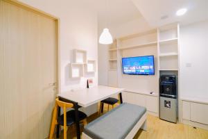 a room with a table and chairs and a tv at Warm and Well Designed 2BR Tokyo Riverside PIK 2 Apartment By Travelio in Rawalembang