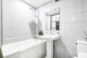 un bagno bianco con lavandino e vasca di Avenue Hotel a Yongin