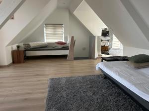 Zimmer im Dachgeschoss mit 2 Betten und einem Teppich in der Unterkunft Willa willi in Niederschaeffolsheim + 3 Fotos