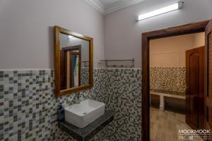 a bathroom with a sink and a mirror at Coconut Lodge in Kampot +86 photos