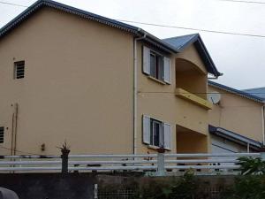 une grande maison avec une clôture devant dans l'établissement Entre mer et montagne, à Le Tampon
